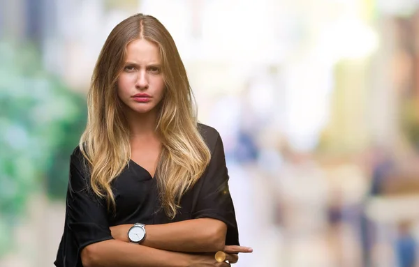 Young beautiful blonde woman over isolated background skeptic and nervous, disapproving expression on face with crossed arms. Negative person.