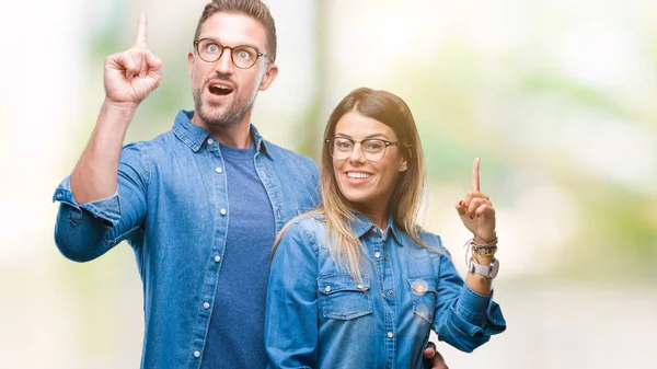 Pareja Joven Enamorada Usando Gafas Sobre Fondo Aislado Apuntando Con —  Fotos de Stock