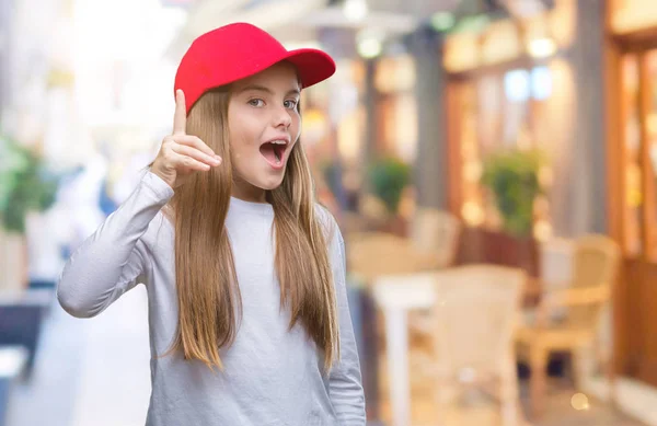 赤い帽子を身に着けている美しい少女は 成功したアイデアで指を上向きの背景を隔離しました 終了したと満足しています ナンバーワン — ストック写真