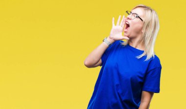 Bağırarak ve ağzı üzerinde el ile yan için çığlık izole arka plan üzerinde gözlük takan genç güzel sarışın bir kadın. İletişim kavramı.