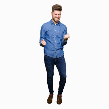 Gülümseyen ve başarı için çığlık rahat kot gömlek çok mutlu ve heyecanlı kaldırdı, silah ile kazanan jest yapıyor genç yakışıklı sarışın adam. Kutlama kavramı.