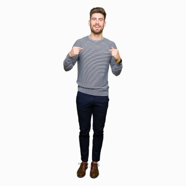 Yüzünde gülümseme ile kendinden emin görünüyorsun, kendini gururlu ve mutlu parmakları ile işaret çizgili süveter giyen genç yakışıklı adam.