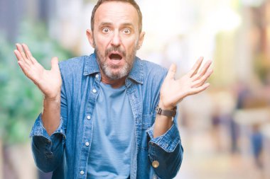 Orta yaş izole arka plan clueless ve şaşkın bir ifadeyle kollar ve eller kaldırdı üzerinde ağarmış komuta sizde. Şüphe kavramı.