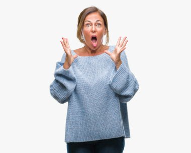 Üzerinde kış kazak giyen orta yaş üst düzey İspanyol kadın deli kutluyor arka plan izole ve başarı için kaldırdı kollarını açarak hayrete ve heyecanlı çığlık gözleri açık. Kazanan kavramı