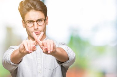 Eksi işareti yapıyor izole arka plan ret ifade geçiş parmakları üzerinde gözlüklü genç yakışıklı adam