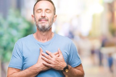 Orta yaş ağarmış komuta sizde ile gülümseyen izole arka plan üzerinde kapalı gözler ve yüzünde minnettar jest ile göğüs üzerinde eller. Sağlık kavramı.