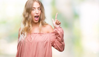 Güzel sarışın genç kadın ile başarılı fikir parmağı yukarıyı izole arka plan üzerinde. Çıktıktan ve mutlu. Bir numara.