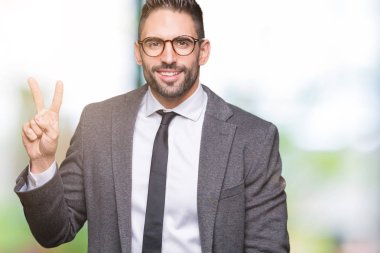 Genç yakışıklı iş adamı gösterilen ve parmakları ile işaret izole arka plan üzerinde ikincisi ise kendinden emin ve mutlu gülümseyerek.