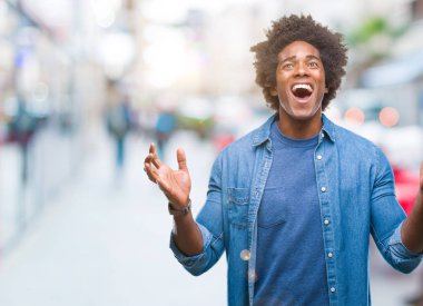 Afro Amerikalı adam kızgın ve silah ile başarı için deli kutluyor izole arka plan üzerinde kaldırdı ve heyecanlı çığlık gözler kapalı. Kazanan kavramı