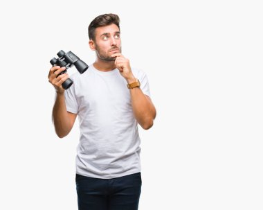 Yakışıklı delikanlı izole arka plan ciddi bir yüz düşünme hakkında soru, çok karışık bir fikir üzerinde dürbün ile seyir