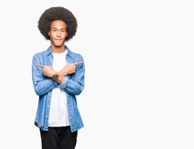 Afro saçlı genç Afro-Amerikan adam işaret parmaklarıyla, farklı yönde iki tarafa da aynı fikirde.