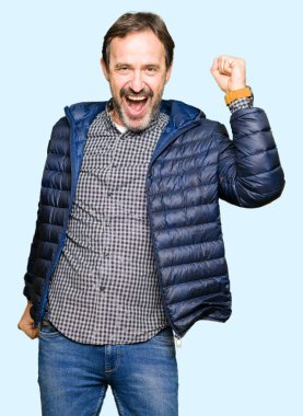 Rahat ve kendinden emin müzik hareket gülümseyen kış ceket dans mutlu ve neşeli, giyen orta yaş yakışıklı adam