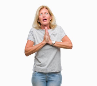 Orta yaş sarışın kadın dilencilik ve umut ifade yüzünde çok duygusal ve endişe ile birlikte elleriyle dua izole arka plan yüzünden. Bağışlanmak. Din kavramı.