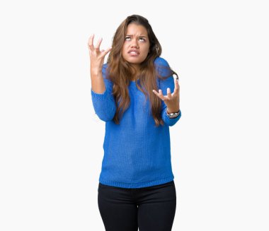 Üzerinde mavi kazak giyen genç güzel esmer kadın arka plan deli izole ve deli bağırarak ve agresif ifade ve silah kaldırdı bağırıyor. Hayal kırıklığı kavramı.