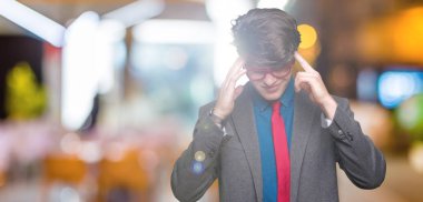 Çünkü çaresiz ve stresli baş ağrısı acı izole arka plan üzerinde kırmızı gözlük takan genç yakışıklı iş adamı ağrı ve Migren. Ellerini kafasına.