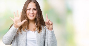 Parmakları ile altı ise kendinden emin ve mutlu gülümseyen güzel artı boyutu genç kadın giyiyor kış ceket ve yukarıyı gösteren izole arka plan üzerinde numara.