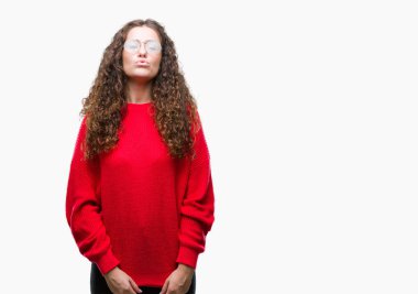 Güzel esmer kıvırcık saçlı Genç kız komik surat ile yanakları şişirme izole arka plan üzerinde gözlük ve kış kazak giyiyor. Ağız ile hava, deli ifade şişirilmiş.