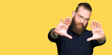 Genç sarışın adam çerçeve kullanarak yapıyor gülen eller avuç içi ve parmaklar, kamera perspektif giyen gözlük ve balıkçı yaka kazak