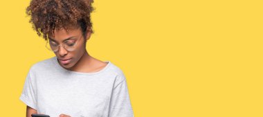 Genç Afro-Amerikan kadın Smartphone akıllı yüzünde ciddi düşünme emin bir ifade ile izole arka plan üzerinde kullanma