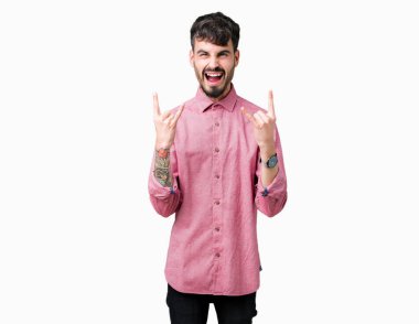 Genç yakışıklı adam izole arka plan üzerinde pembe gömlek giyen elleri ile rock sembolü yapıyor deli ifade ile bağırarak. Müzik yıldızı. Ağır konsept.