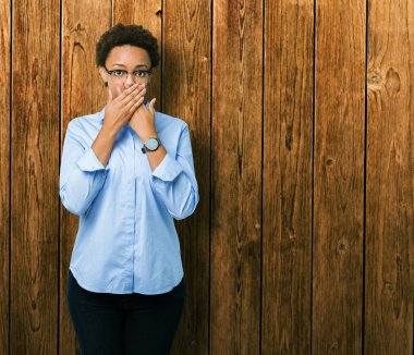 Genç güzel Afro-Amerikan iş kadın izole arka plan ağız hata için elleriyle kapsayan şok yüzünden. Gizli kavramı.