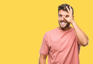 Genç yakışıklı adam gülümsüyor, parmakları ile mutlu yüz üzerinden seyir göz el ile ok jest yapıyor izole arka plan üzerinde.