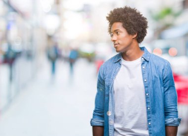 Uzak tarafına yüzünde, doğal ifade gülümseme ile seyir izole arka plan üzerinde Afro Amerikalı adam. Kendine güvenen gülüyor.