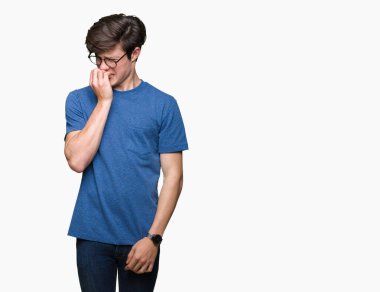 Genç yakışıklı adam stresli ve gergin ile izole arka plan üzerinde gözlük takan tırnak ısırma dudaklarından eller. Anksiyete sorunu.