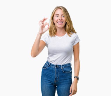 İzole arka plan el ve parmaklar ok işaretiyle yapıyor olumlu gülümseyen üzerinde rahat beyaz t-shirt giyen güzel ve genç birbayan. Başarılı ifade.