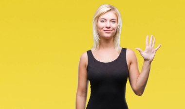 Gösterilen ve parmakları ile işaret izole arka plan üzerinde zarif elbise genç güzel sarışın çekici bir kadın kendinden emin ve mutlu gülümseyerek süre beş numara.