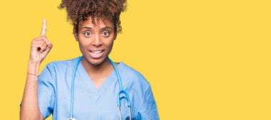 Genç Afro-Amerikan doktor kadın başarılı fikirle parmağı yukarıyı izole arka plan yüzünden. Çıktıktan ve mutlu. Bir numara.