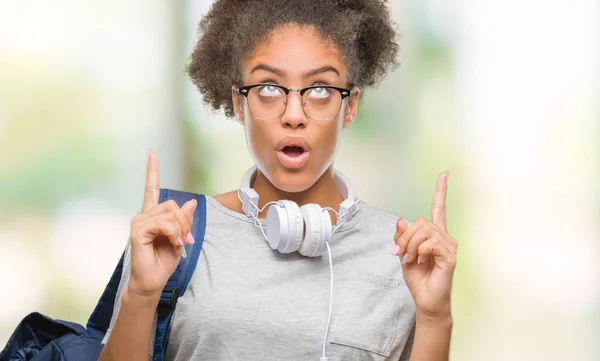 Joven Estudiante Afroamericana Con Auriculares Mochila Sobre Fondo Aislado Asombrada —  Fotos de Stock
