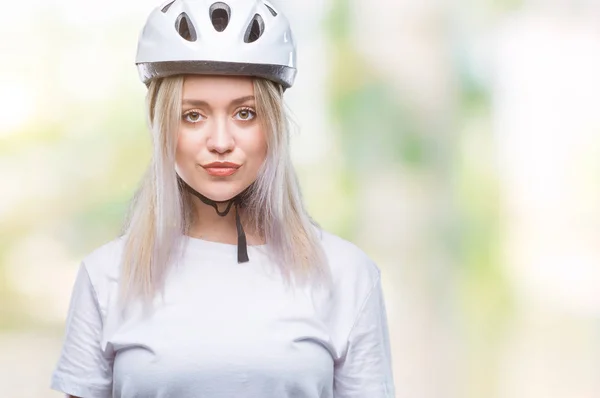年轻的金发女子穿着自行车安全头盔在孤立的背景下 面部表情严肃 简单而自然地看着相机 — 图库照片