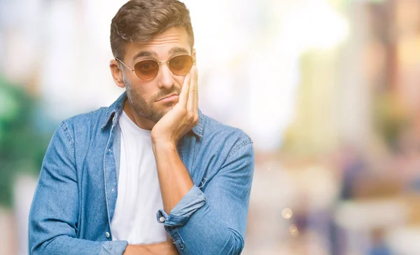 年轻英俊的男子戴着太阳镜在孤立的背景下思考看累了 厌倦了与交叉手臂抑郁症问题 — 图库照片