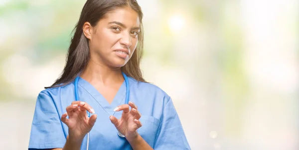 Young arab doctor surgeon woman over isolated background disgusted expression, displeased and fearful doing disgust face because aversion reaction. With hands raised. Annoying concept.