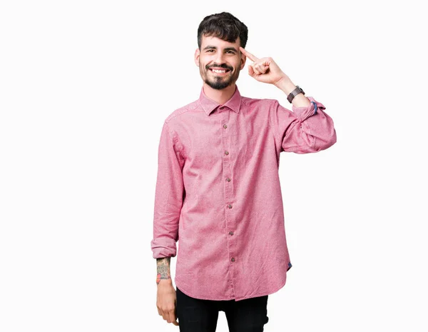 年轻英俊的男人穿着粉红色的衬衫在孤立的背景微笑着用一根手指指着头 伟大的想法或想法 良好的记忆力 — 图库照片
