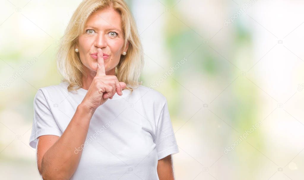 Middle age blonde woman over isolated background asking to be quiet with finger on lips. Silence and secret concept.