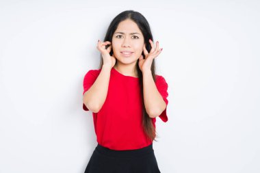 Yüksek sesle müzik gürültü rahatsız ifade parmaklarıyla kulaklarıyla kapsayan izole arka plan üzerinde kırmızı t-shirt giyen güzel esmer kadın. Sağır kavramı.