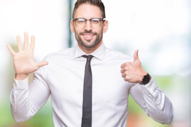 Gösterilen arka plan üzerinde gözlük takan genç yakışıklı iş adamı izole ve parmakları ile işaret kendinden emin ve mutlu gülümseyerek süre 6 numara.