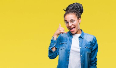 Genç örgülü saç Afro-Amerikan kız yapıyor gülümseyen izole arka plan üzerinde gözlük telefon hareketi ile el ve parmak telefonda konuşuyor gibi. Kavramları iletişim.
