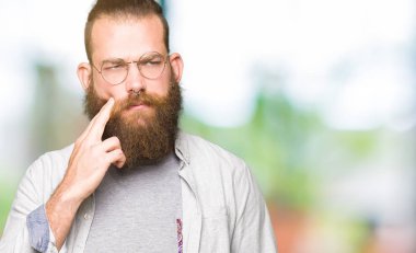 Diş ağrısı veya dişlerde dişlerle ilgili hastalık nedeniyle ağız acı ifadesi ile el ile dokunmak gözlüklü genç sarışın adam. Diş hekimi kavramı.