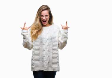 Kış kazak ve güneş gözlüğü deli ifade rock simge elle yapıyor ile bağırarak izole arka plan üzerinde giyen genç güzel sarışın kadın. Müzik yıldızı. Ağır kavramı.