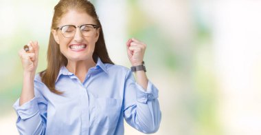 Zafer kutluyor gülümseyen izole arka kolları olan başarı için heyecan üzerinde gözlük güzel orta yaş olgun iş kadını kaldırdı. Kazanan kavramı.