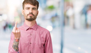Yakışıklı delikanlı izole arka plan gösteren orta parmak, kaba ve kaba siktir git ifade üzerinde pembe gömlek giymiş