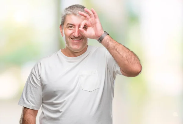 幸せそうな顔で指を通して見る目の手で のジェスチャーを行う分離の背景にハンサムな年配の男性 — ストック写真