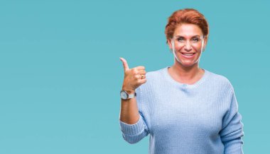 Atrractive üst düzey beyaz Kızıl saçlı kadın hareketi el ile mutlu yaşasın yapıyor izole arka plan yüzünden. Kameraya bakarak başarı gösteren ile ifade onaylama.