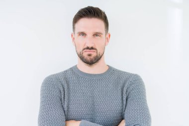 İzole arka plan şüpheci ve sinir, onaylamayan ifade yüz çapraz kolları üzerinde rahat kazak giyen genç yakışıklı adam. Negatif kişi.