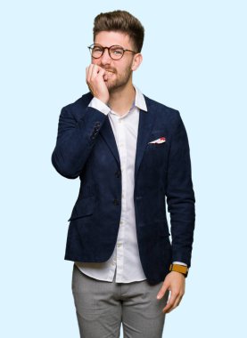 Stresli ve gergin elle çivi ısırma ağzına bakarak gözlüklü genç yakışıklı iş adamı. Anksiyete sorunu.