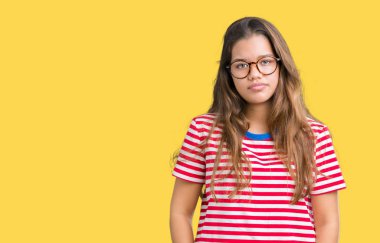 Giyen genç güzel esmer kadın gözlük ve t-shirt yüzünde ciddi bir ifade ile izole arka plan üzerinde çizgili. Basit ve doğal kameraya bakıyor.