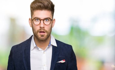 Korkuyor ve şok sürpriz ifade, korku ve heyecan yüz ile gözlüklü genç yakışıklı iş adamı.